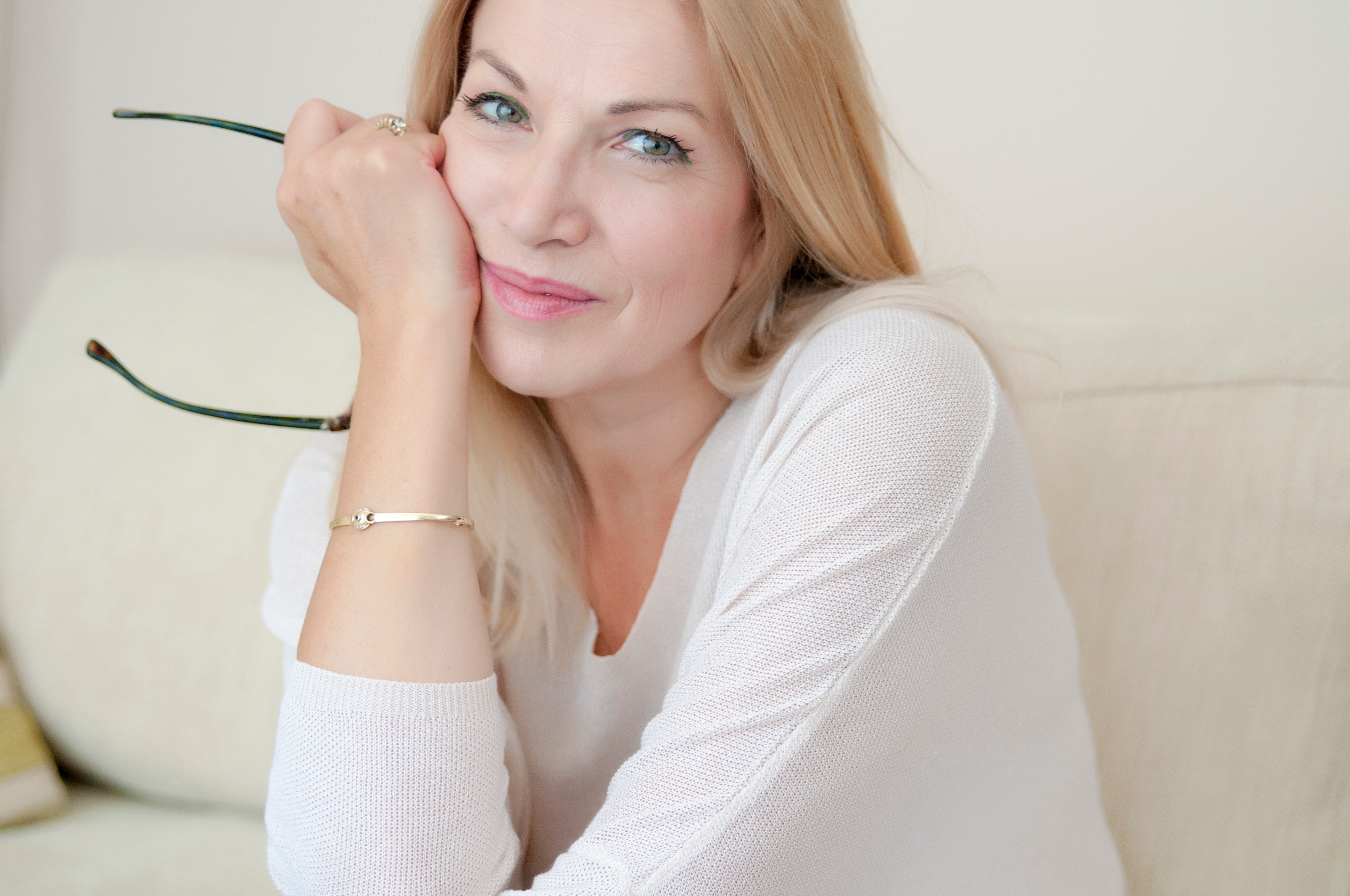 Eine Frau mittleren Alters, die nachdenklich und jugendlich wirkt.